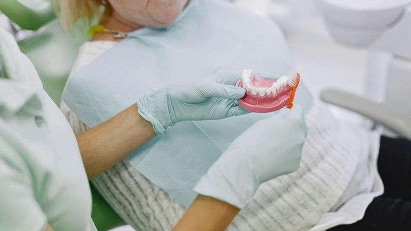 Vệ sinh khoang miệng và lắp hàm giả cho bệnh nhân, sau đó hướng dẫn bệnh nhân cách vệ sinh và chăm sóc răng miệng tại nhà